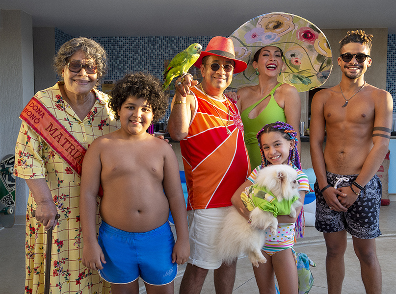 VIZINHOS. (L to R) DJA MARTINS as DONA NONO, YVES MIGUEL as PEDROCA, MAURICIO MANFRINI as TONINHO, MARLEI CEVADA as KELLY, SOPHIA GUEDES as SACHA, LUCAS LETO as ARTHUZINHO in VIZINHOS. Natalia Odenbreit/NETFLIX © 2022